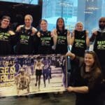 The team gathered for a picture holding behind a Bob Hall banner that reads: The Push that Changed the World.