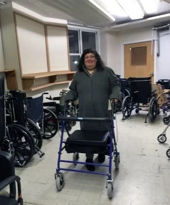 Smiling woman with rollator in a room full of DME.
